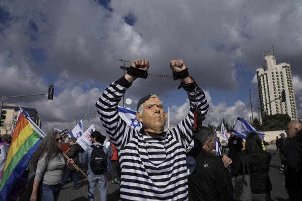 FILE - A man wears a mask depicting Israeli Prime Minister Benjamin Netanyahu in front of the Supreme Court in Jerusalem during a protest against the appointment of Aryeh Deri, the leader of the ultra-Orthodox Shas party as the country's new health minister, Thursday, Jan, 5, 2023. Netanyahu's corruption trial has resumed after a month-long break. The resumption refocuses the spotlight on the long-serving leader's legal woes after a wave of protests over his government's plan to overhaul the country's judiciary. (AP Photo/Mahmoud Illean, File)