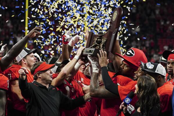Georgia head coach Kirby Smart and defensive lineman Jalen Carter (88) hoist the trophy after defeating LSU in the Southeastern Conference Championship football game Saturday, Dec. 3, 2022 in Atlanta. (AP Photo/John Bazemore)
