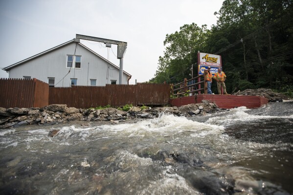 Water flows along a roadway impacted by recent storms and flooding, Monday, July 17, 2023, in Belvidere, New Jersey. (AP Photo/Eduardo Munoz Alvarez)
