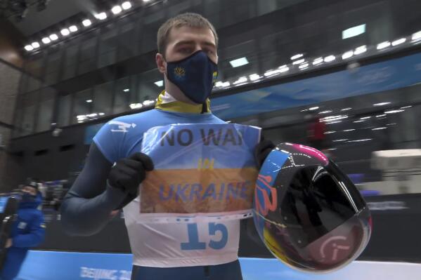FILE - In this frame from video, Vladyslav Heraskevych, of Ukraine, holds a sign that reads "No War in Ukraine" after finishing a run at the men's skeleton competition at the 2022 Winter Olympics, Friday, Feb. 11, 2022, in the Yanqing district of Beijing. (NBC via AP, File)