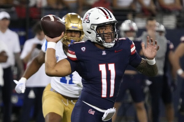 Arizona quarterback Noah Fifita throws a pass against UCLA during the first half of an NCAA college football game Saturday, Nov. 4, 2023, in Tucson, Ariz. (AP Photo/Rick Scuteri)