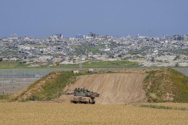 Israeli soldiers rest on top of their tank on the border with the Gaza Strip, in southern Israel, Wednesday, April 3, 2024. (AP Photo/Tsafrir Abayov)