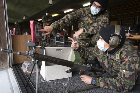 FILE - Soldiers of the Swiss army wear protective face masks during a rifle shooting exercise in the military compound of Chamblon near Yverdon-les-Bains, Switzerland, on April 30, 2020. Switzerland鈥檚 government plans to boost its defense spending by up to 19% over the next four years. It cites rising global instability, through war in places like Ukraine and the Middle East. (Laurent Gillieron/Keystone via 番茄直播, File)