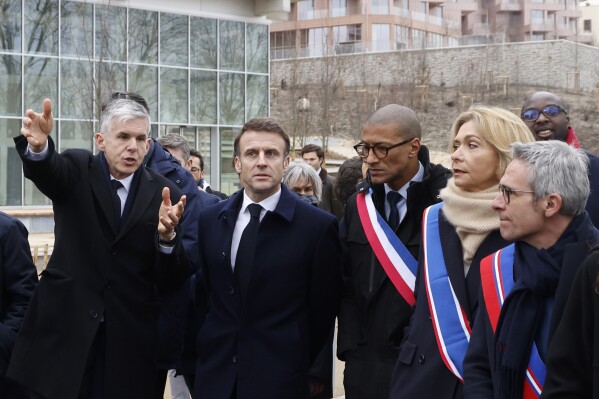France's President Emmanuel Macron, center left, and General Manager of Solideo Nicolas Ferrand, left, visits the Paris 2024 Olympic village during its inauguration ceremony in Saint-Denis, north of Paris, Thursday, Feb. 29, 2024. (Ludovic Marin, Pool via AP)