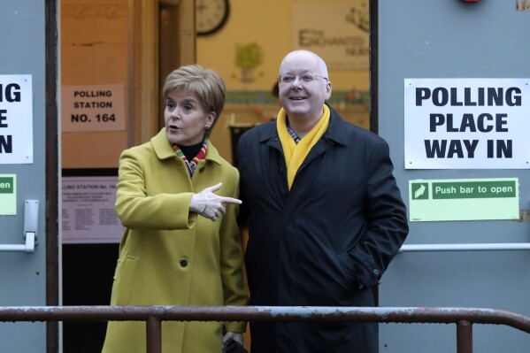 FILE - Scottish First Minister Nicola Sturgeon poses for the media with husband Peter Murrell, outside polling station in Glasgow, Scotland, on Dec. 12, 2019. The husband of former Scottish First Minister Nicola Sturgeon has been re-arrested in a probe into the finances of Scotland's pro-independence governing party. Police Scotland said a 59-year-old man had been taken into custody on Thursday, April 18, 2024 and was being questioned by detectives. While police did not name the suspect, the details provided matched up with Peter Murrell, the party's ex-chief executive who was first arrested over a year ago. (AP Photo/Scott Heppell, File)