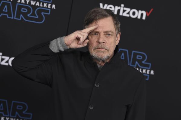 FILE - Mark Hamill salutes as he arrives at the world premiere of "Star Wars: The Rise of Skywalker" in Los Angeles on Dec. 16, 2019. When air raid alarms sound in Ukraine, they also trigger a downloadable app that has been voiced by “Star Wars” actor Mark Hamill. With his gravely but also calming baritone, he urges people to take cover. He also tells them when the danger has passed, signing off with “May the Force be with you.” In an interview with The Associated Press, the actor said he’s admiring Ukraine's resilience from afar in California.(Jordan Strauss/Invision/AP, File)
