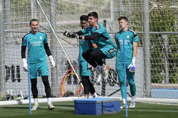 FILE - Real Madrid's goalkeeper Thibaut Courtois, 3rd left trains watched by reserve goalkeeper Andriy Lunin, left, during a Media Opining day training session in Madrid, Spain, on May 24, 2022. Real Madrid coach Carlo Ancelotti has started his casting for which goalkeeper – Thibaut Courtois or Andriy Lunin – will start the Champions League final. Ancelotti said Friday May 10, 2024 that he had one month “to think about it." (AP Photo/Manu Fernandez, File)