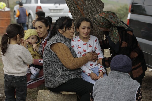 Ethnic Armenians from Nagorno-Karabakh comfort a young woman upon arriving to Kornidzor in Syunik region, Armenia, Tuesday, Sept. 26, 2023. Some 42,500 people, or about 35% of Nagorno-Karabakh's ethnic Armenian population, had left for neighboring Armenia as of Wednesday morning, according to Armenian authorities. Hours-long traffic jams were reported on Tuesday on the road linking Nagorno-Karabakh to Armenia. (AP Photo/Vasily Krestyaninov)