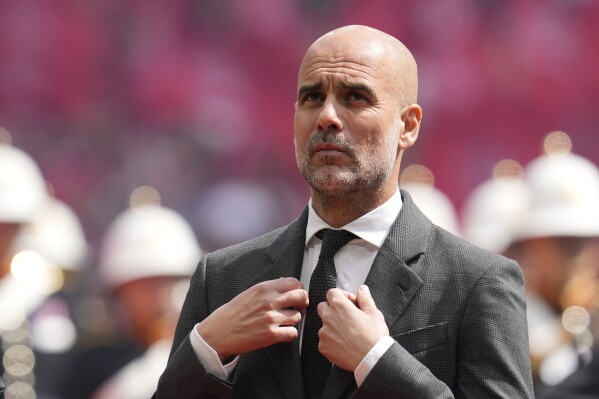 Manchester City's head coach Pep Guardiola gestures prior to the English FA Cup final soccer match between Manchester City and Manchester United at Wembley Stadium in London, Saturday, May 25, 2024. (AP Photo/Kin Cheung)