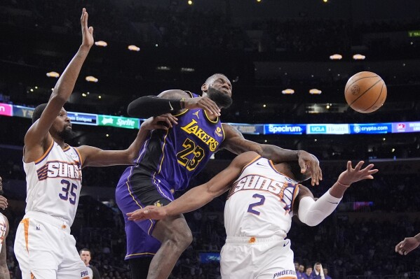 Los Angeles Lakers forward LeBron James, loses control of the ball after being fouled as Phoenix Suns forward Kevin Durant, left, and forward Josh Okogie defend during the first half of an NBA basketball game Thursday, Jan. 11, 2024, in Los Angeles. (AP Photo/Mark J. Terrill)
