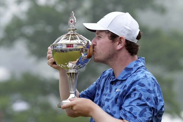 Scotland's Robert MacIntyre kisses the championship trophy after winning the Canadian Open golf tournament in Hamilton, Ontario, Sunday, June 2, 2024. (Nathan Denette/The Canadian Press via AP)