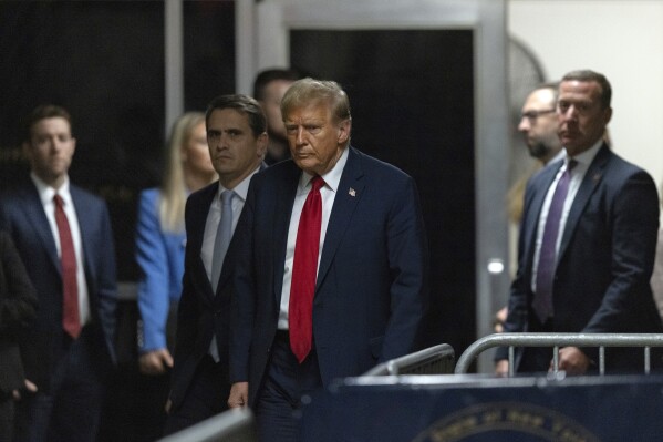 Former President Donald Trump, center, with his attorney, Todd Blanche, left, walks outside of the courtroom of his trial as he exits Manhattan criminal court in New York, Thursday, April 25, 2024.  (Jeenah Moon/Pool Photo via AP)