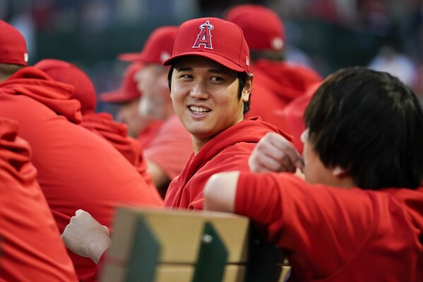Los Angeles Angels' Shohei Ohtani talks with his translator Ippei Mizuhara, right, in the dugout during the first inning of a baseball game against the Oakland Athletics in Anaheim, Calif., Saturday, Sept. 30, 2023. (AP Photo/Ashley Landis)