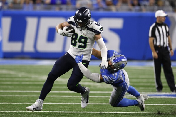 Seattle Seahawks tight end Will Dissly (89) tries to break a tackle by Detroit Lions linebacker Malcolm Rodriguez (44) during the second half of an NFL football game, Sunday, Sept. 17, 2023, in Detroit. (AP Photo/Duane Burleson)