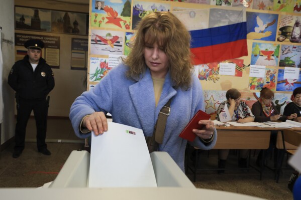 A woman casts a ballot at a polling station during a presidential election in Simferopol, Crimea, Friday, March 15, 2024. People in Moscow-controlled Ukrainian regions voted in Russia's presidential election, which wass all but certain to extend President Vladimir Putin's rule after he clamped down on dissent. (AP Photo)