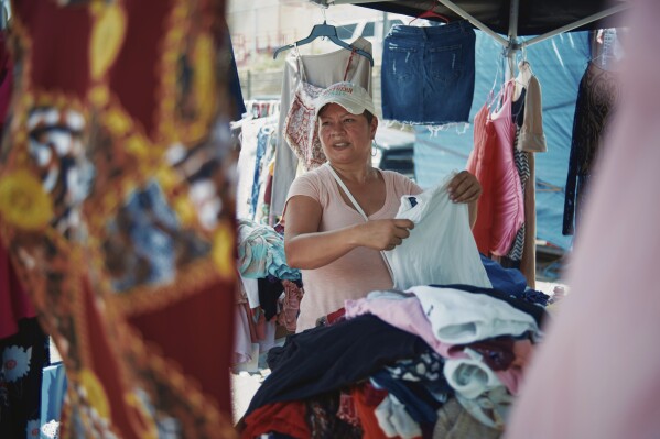 Amber Cardenas, 42, sells clothing at a flea market near Shelby Park in Eagle Pass, Texas, on Friday, Aug. 9, 2024. (Jordan Vonderhaar/The Texas Tribune via AP)