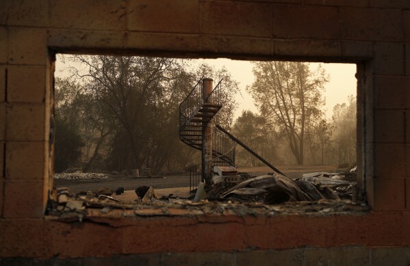 FILE - A spiral staircase stands in the remains of a burned out home from the Camp Fire, Nov. 10, 2018, in Paradise, Calif. With a housing crisis that has priced out many Native Hawaiians as well as families that have been there for decades, concerns are rising that Maui could become the latest example of “climate gentrification,” when it becomes harder for local people to afford housing in safer areas after a climate-amped disaster. Other examples include New Orleans after Hurricane Katrina in 2005 and Paradise, Calif., after the 2018 Camp Fire. (AP Photo/John Locher, File)