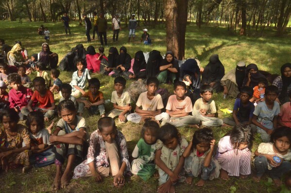 Ethnic Rohingya people sit on a beach after they land in Kuala Parek Beach, East Aceh, Aceh province, Indonesia, Thursday, Feb. 1, 2024. Across a treacherous stretch of water, the Rohingya came by the thousands, then died by the hundreds. And though they know the dangers of fleeing by boat, many among this persecuted people say they will not stop — because the world has left them with no other choice. (AP Photo/Husna Mura)