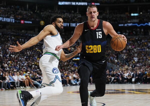Denver Nuggets center Nikola Jokic, right, drives past Minnesota Timberwolves center Karl-Anthony Towns in the first half of Game 7 of an NBA second-round playoff series, Sunday, May 19, 2024, in Denver. (AP Photo/David Zalubowski)