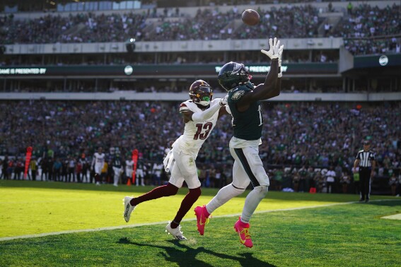 Philadelphia Eagles wide receiver A.J. Brown (11) reaches for a touchdown catch in front of Washington Commanders cornerback Emmanuel Forbes (13) during the second half of an NFL football game Sunday, Oct. 1, 2023, in Philadelphia. (AP Photo/Matt Rourke)