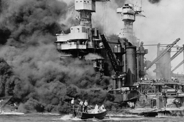
              FILE - In this Dec. 7, 1941 photo made available by the U.S. Navy, a small boat rescues a seaman from the USS West Virginia burning in the foreground in Pearl Harbor, Hawaii, after Japanese aircraft attacked the military installation. A few dozen survivors of the Japanese attack on Pearl Harbor plan to gather in Hawaii, Wednesday, Dec. 7, 2016, to remember those killed 75 years ago. (U.S. Navy via AP, File)
            