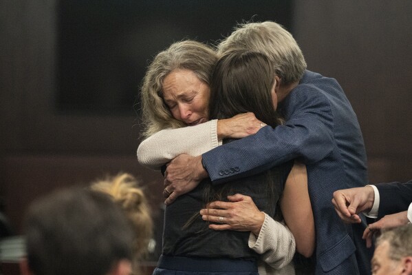 Parents of Anna Moriah Wilson, Karen Wilson and Eric Wilson, embrace Caitlin Cash, friend of Anna 