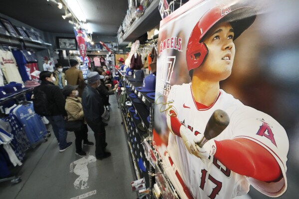 Customers shop around for character goods of Shohei Ohtani of the Los Angeles Dodgers at a sporting goods store, "SELECTION," in Shinjuku district Wednesday, Dec. 13, 2023, in Tokyo. Ohtani agreed to a record $700 million, 10-year contract with the Los Angeles Dodgers. (AP Photo/Eugene Hoshiko)