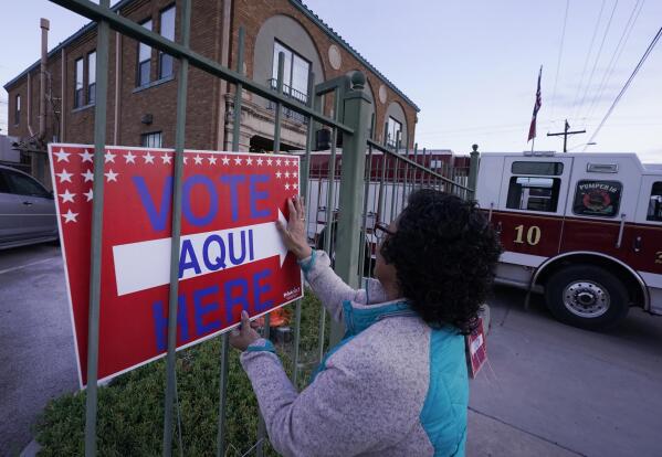 FILE - Election worker Ramona Ortiz places a sign outside a polling station at Fire Station 3 on E. Rio Grande Ave in El Paso, Texas, just before polls open on Nov. 8, 2022. Next year is shaping up to be another busy for state legislatures seeking to change voting laws. (AP Photo/LM Otero, File)