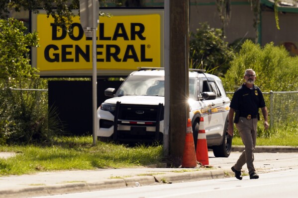 Law enforcement officials continue their investigation at a Dollar General Store that was the scene of a mass shooting, Sunday, Aug. 27, 2023, in Jacksonville, Fla. (AP Photo/John Raoux)