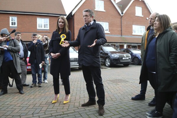 In this photo dated Saturday, Dec. 7, 2019, British actor Hugh Grant poses for a photo with Liberal Democrats Party election candidate Monica Harding, during an election campaign visit in the Esher and Walton constituency, Walton-on-Thames, England.  Hugh Grant has been on the campaign trail with the Liberal Democrats to stop Britain's Brexit from Europe and urging voters to kick Prime Minister Boris Johnson out of office when Britain goes to the polls on Dec. 12. (Gareth Fuller/PA via AP)