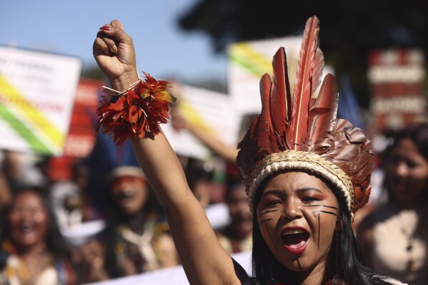 FILE - An Indigenous woman marches during the 20th annual Free Land Indigenous Camp in Brasilia, Brazil, April 23, 2024. Thousands of Indigenous people continue to march on Thursday, April 25, calling on the government to officially recognize lands they have lived on for centuries and to protect territories from criminal activities like illegal mining. (AP Photo/Luis Nova, File)