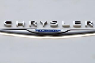 FILE -  The Chrysler logo at the 2019 Pittsburgh International Auto Show is displayed on Feb. 14, 2019.  Chrysler says, Wednesday, Jan. 5, 2022, it plans for its vehicle lineup to go all electric by 2028. It's the latest brand to announce a major shift away from gas-powered cars amid pressure to act on climate change.  (AP Photo/Gene J. Puskar, file)