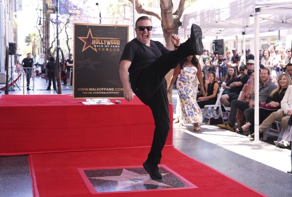 Comedian Ricky Gervais celebrates with a kick at a ceremony honoring him with a star on the Hollywood Walk of Fame on Friday, May 30, 2025, in Los Angeles. (AP Photo/Chris Pizzello)