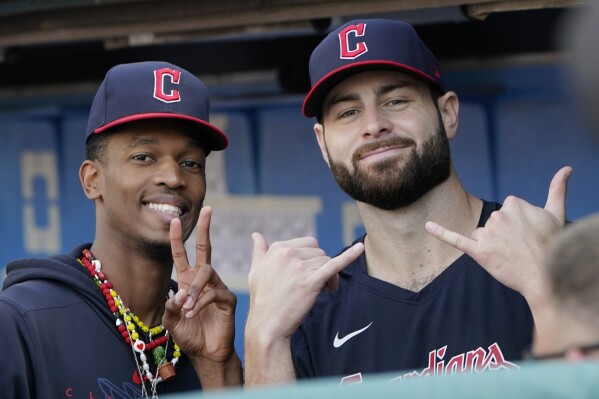 Cleveland Guardians pitchers Triston McKenzie, left, and Lucas Giolito, right, gesture from the dugout in the first inning of a baseball game against the Tampa Bay Rays, Sunday, Sept. 3, 2023, in Cleveland. (AP Photo/Sue Ogrocki)