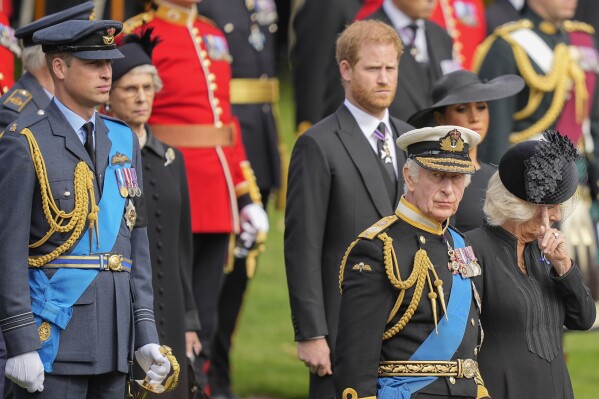 FILE - King Charles III, front right, Camilla, the Queen Consort, Prince Harry and Prince William watch as Queen Elizabeth II's coffin is placed in the hearse after the state funeral at Queen Elizabeth Abbey. Westminster in central London on Monday, September 19, 2022. King Charles III has been diagnosed with a form of cancer and has started treatment, Buckingham Palace says on Monday, February 5, 2024. (AP Photo/Martin Meissner, Pool, Archive)