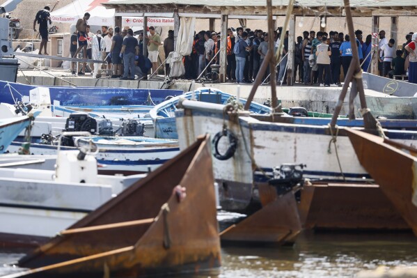 Migrants stand on the dock of the port of the Sicilian island of Lampedusa, southern Italy, Monday, Sept. 18, 2023, a day after European Commission President Ursula von der Leyen visited the island, overwhelmed with thousands of migrants arrivals the past week. (Cecilia Fabiano/LaPresse via AP)