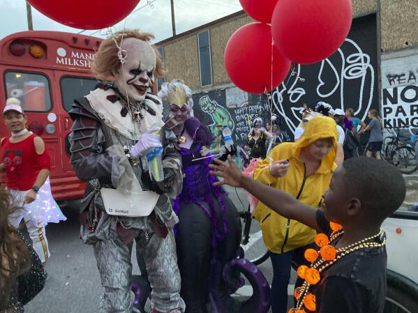 A costumed man greets a young boy at the Krewe of Boo parade on Saturday, Oct. 23, 2021, in New Orleans. (AP Photo/Rebecca Santana)