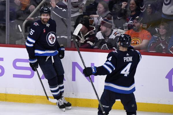 Winnipeg Jets' Blake Wheeler (26) celebrates his hat-trick goal against the Colorado Avalanche with Neal Poink (4) during the third period of an NHL hockey game Tuesday, Nov. 29, 2022, in Winnipeg, Manitoba. (Fred Greenslade/The Canadian Press via AP)