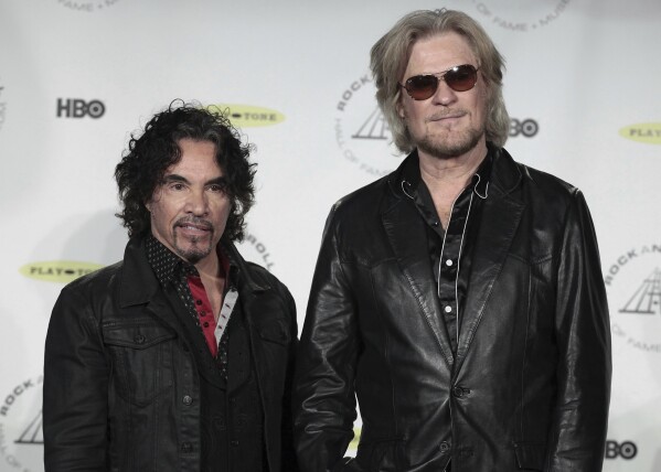 FILE - Hall of Fame Inductees John Oates, left, and Daryl Hall appear in the press room at the Rock and Roll Hall of Fame Induction Ceremony on April, 10, 2014, in New York. After more than a half-century of making music together, Hall is suing Oates over a proposed sale of his share of a Hall & Oates business partnership that Hall says he hasn't approved. A Nashville judge recently paused the sale of Oates' stake in Whole Oats Enterprises LLP to Primary Wave IP Investment Management LLC pending arbitration, or until Feb. 17, 2024. (Photo by Andy Kropa/Invision/AP, File)