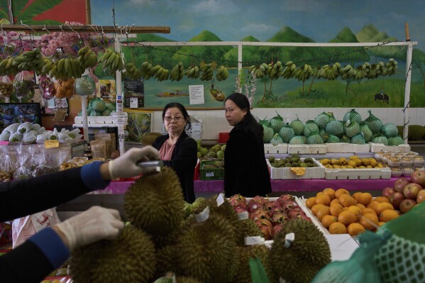 Two Vietnamese women shop for fruit at a market in the Little Saigon neighborhood of Westminster, Calif., Friday, April 25, 2025. (AP Photo/Jae C. Hong)