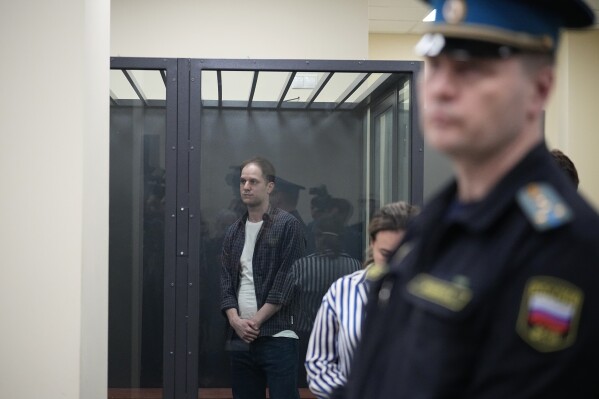 Wall Street Journal reporter Evan Gershkovich stands in a glass cage in a courtroom at the First Appeals Court of General Jurisdiction in Moscow, Russia, Tuesday, April 23, 2024. (AP Photo/Alexander Zemlianichenko)