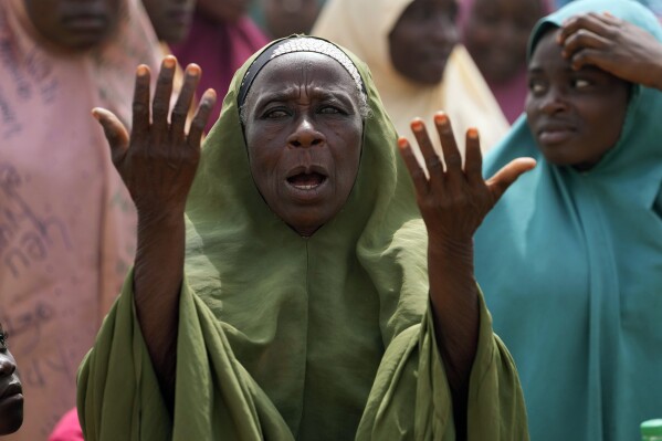 A woman prays for the kidnapped LEA Primary and Secondary School students in Kuriga, Kaduna state Nigeria, Saturday, March 9, 2024. Security forces swept through large forests in Nigeria's northwest region on Friday in search of nearly 300 children who were abducted from their school a day earlier in the West African nation's latest mass kidnap which analysts and activists blamed on the failure of intelligence and slow security response. (AP Photo/Sunday Alamba)