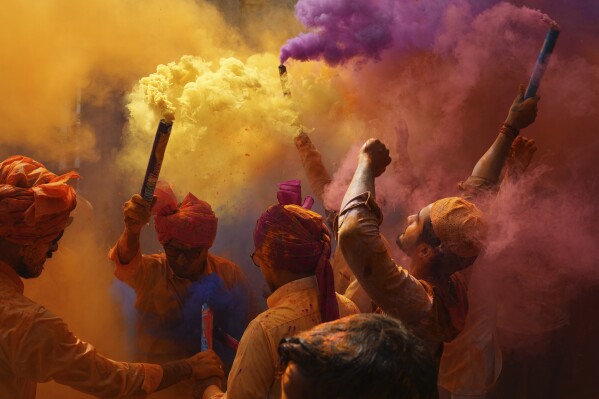 People dance and throw colors at each other to celebrate Holi, the Hindu festival of colours, in Hyderabad, India, Monday, March 6, 2023. (AP Photo/Mahesh Kumar A.)