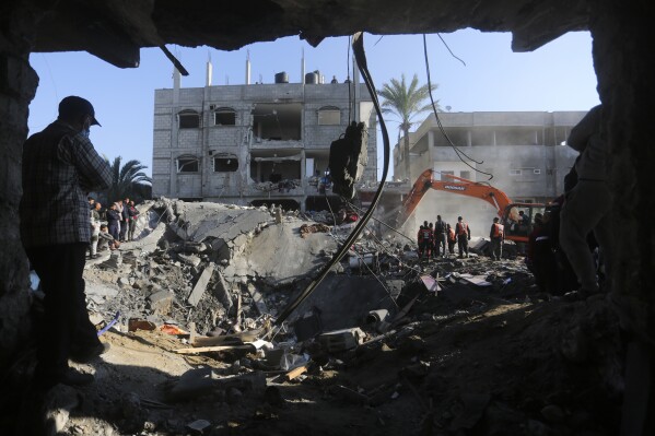 Palestinians search for survivors after the Israeli bombardment of the Gaza Strip outside a morgue in Rafah, Tuesday, Dec. 19, 2023. (AP Photo/Hatem Ali)