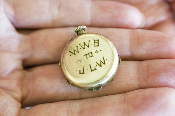 Renee Robinson, executive director of Hanover and King William Habitat for Humanity, holds an old pendant watch at her office in Mechanicsville, Va., on Tuesday, June 27, 2023. Engravings on the watch are "WWB" stands for Wesley William Brannon and "JLW" does for Joseph (Josie) Lewis White. (Daniel Sangjib Min/Richmond Times-Dispatch via AP)