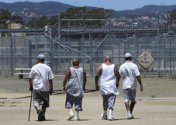 FILE - Inmates walk the exercise yard at the California Medical Facility in Vacaville, Calif., June 20, 2018. California would allow more ill and dying inmates to be released from state prisons under legislation that cleared the state Senate and heads to the Assembly for final approval. (AP Photo/Rich Pedroncelli, File)