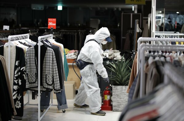 A worker wearing protective gear sprays disinfectant as a precaution against the new coronavirus at a department store in Seoul, South Korea, Monday, March 2, 2020. South Korea has the world's second-highest cases. (AP Photo/Lee Jin-man)