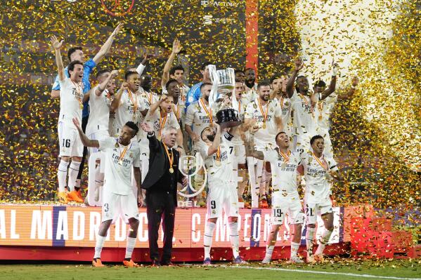 Real Madrid team players and head coach Carlo Ancelotti celebrate with the trophy after Madrid defeated Osasuna 2-1 in the Copa del Rey soccer final at La Cartuja stadium in Seville, Spain, Saturday, May 6, 2023. (AP Photo/Jose Breton)