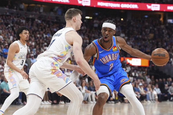 Oklahoma City Thunder guard Shai Gilgeous-Alexander, right, drives to the basket as Denver Nuggets guard Christian Braun defends in the second half of Game 6 in the Western Conference semifinals of the NBA basketball playoffs Thursday, May 15, 2025, in Denver. (AP Photo/David Zalubowski)