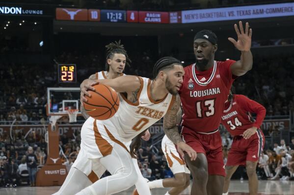Texas forward Timmy Allen (0) drives the ball against Louisiana-Lafayette guard Greg Williams, Jr. (13) during the first half of an NCAA college basketball game, Wednesday, Dec. 21, 2022, in Austin, Texas. (AP Photo/Michael Thomas)